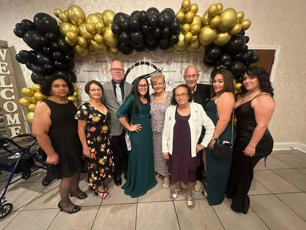 Family celebrating with balloon arch.