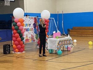 Woman speaking at birthday party.