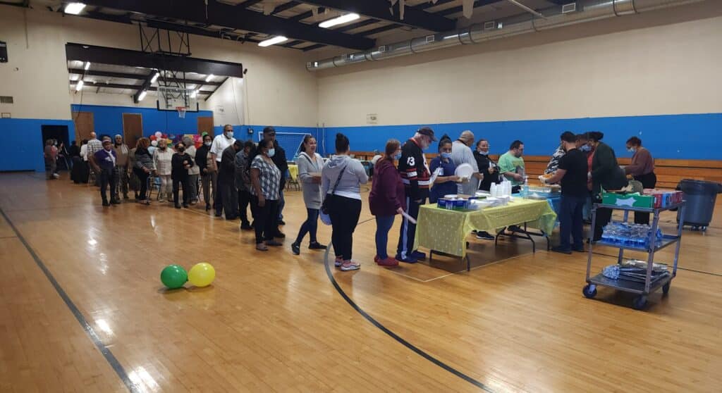 People gathering for a meal in a gym.