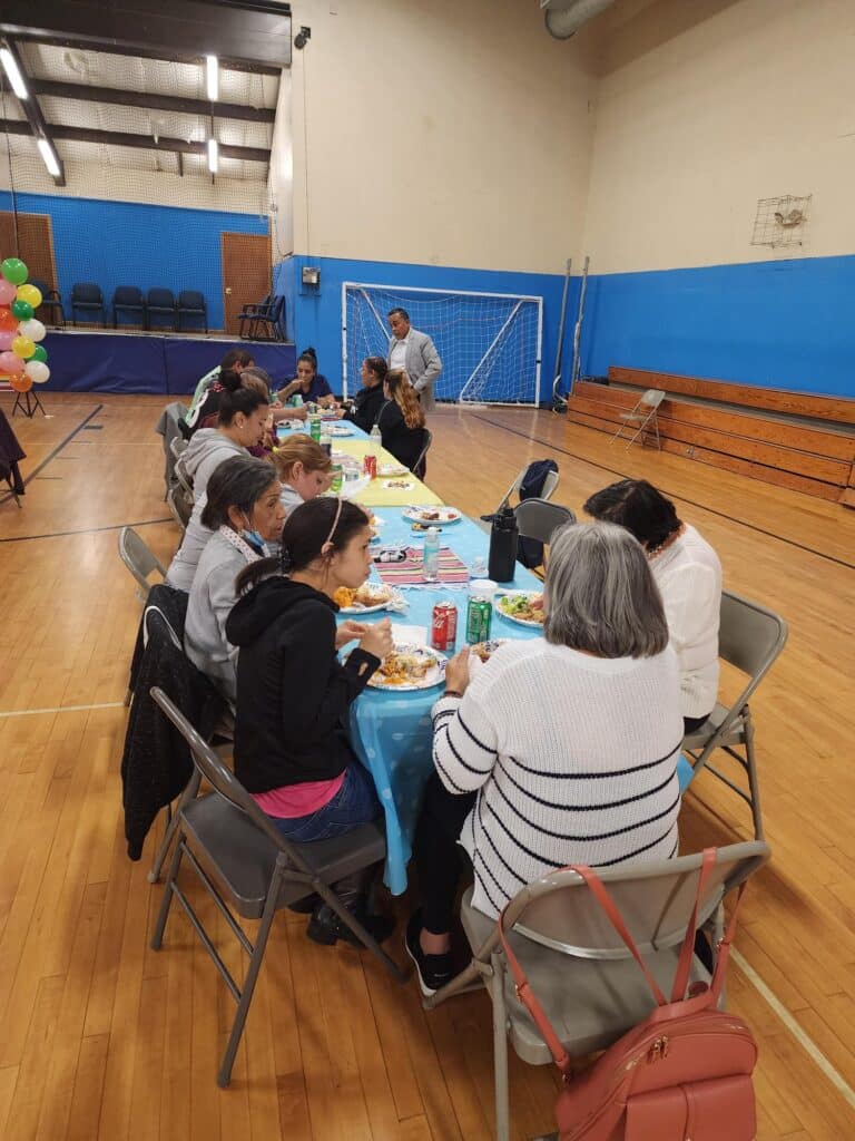 Group of people eating in a gym.