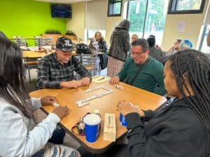 People playing dominoes at a table.