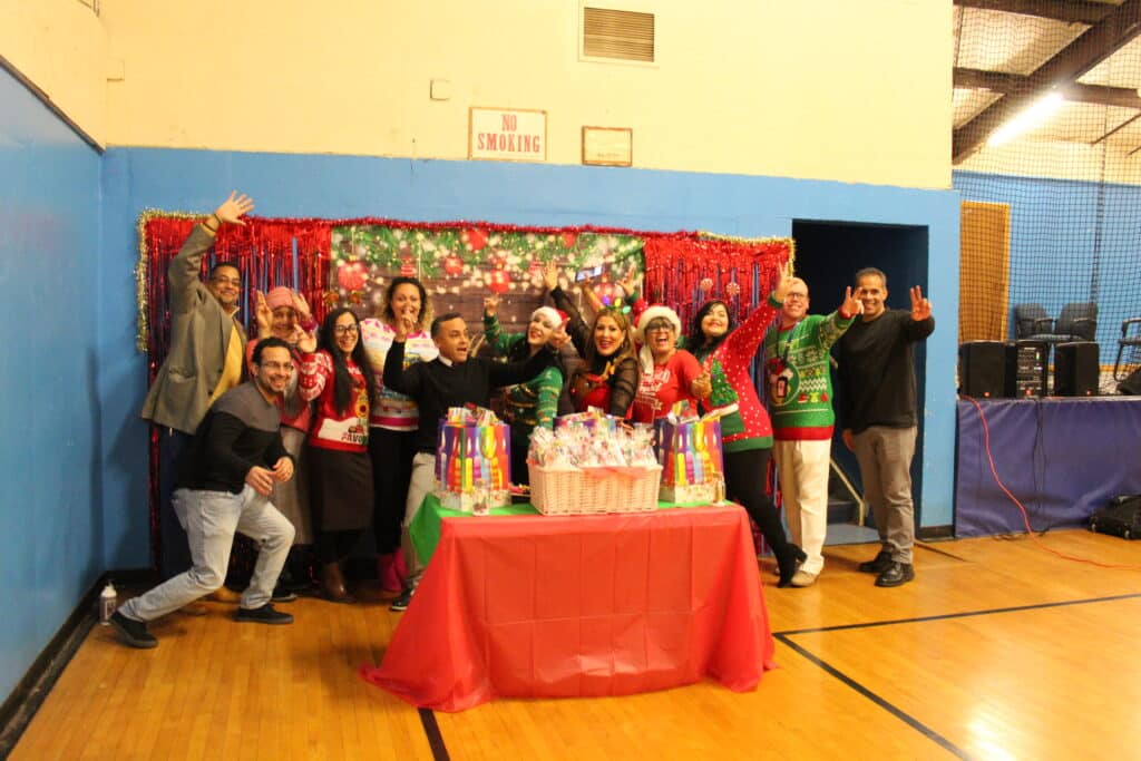 A group of people standing around a table with cake.