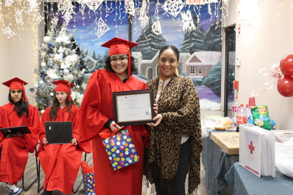 A woman holding an award and standing next to another person.