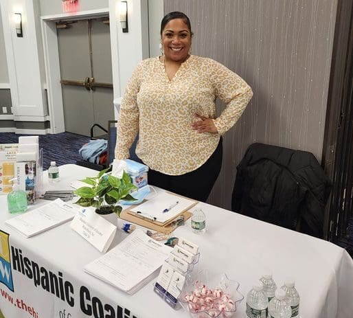 Woman smiling at Hispanic Coalition event.