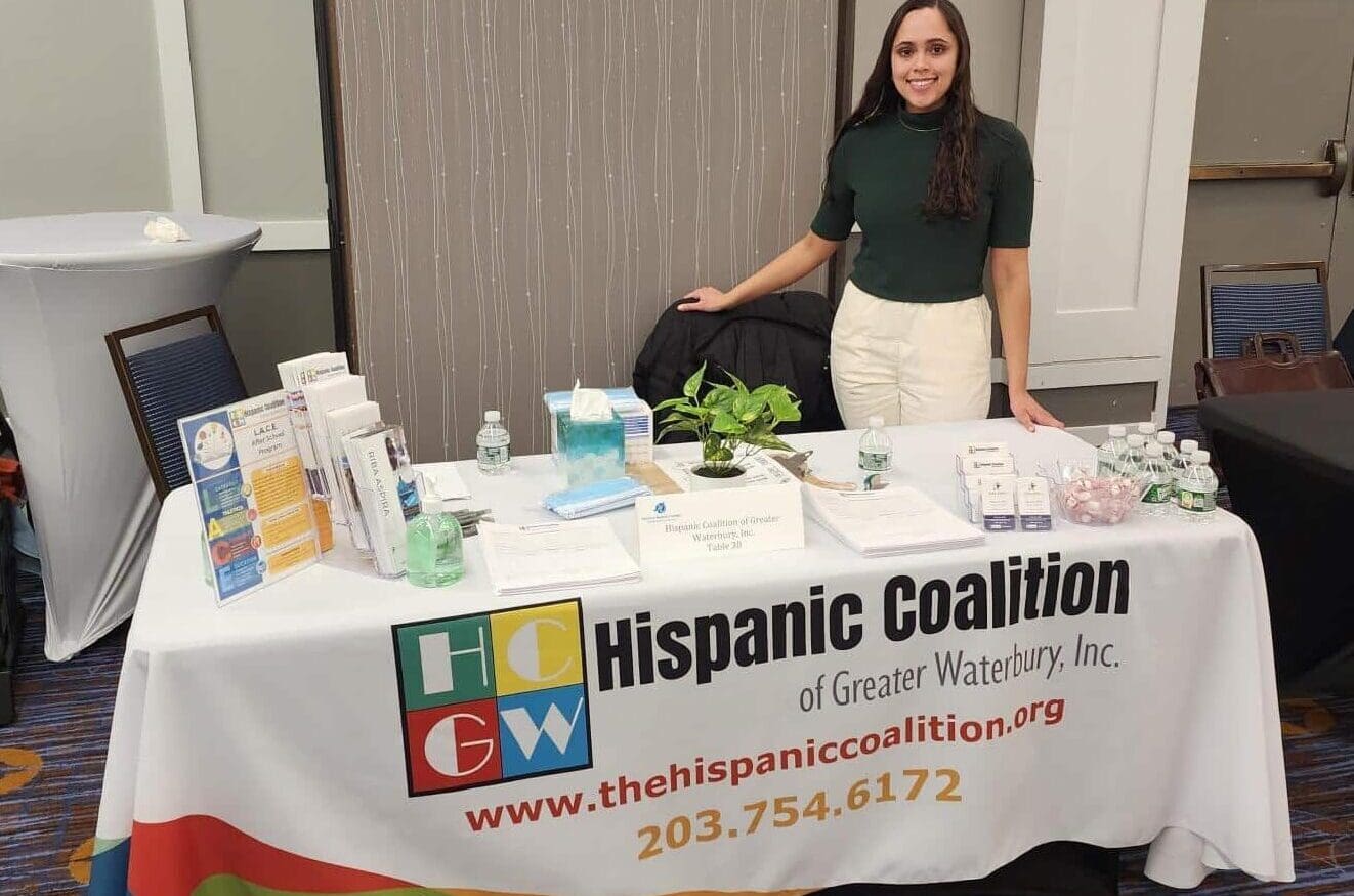 A woman standing next to a table with some papers