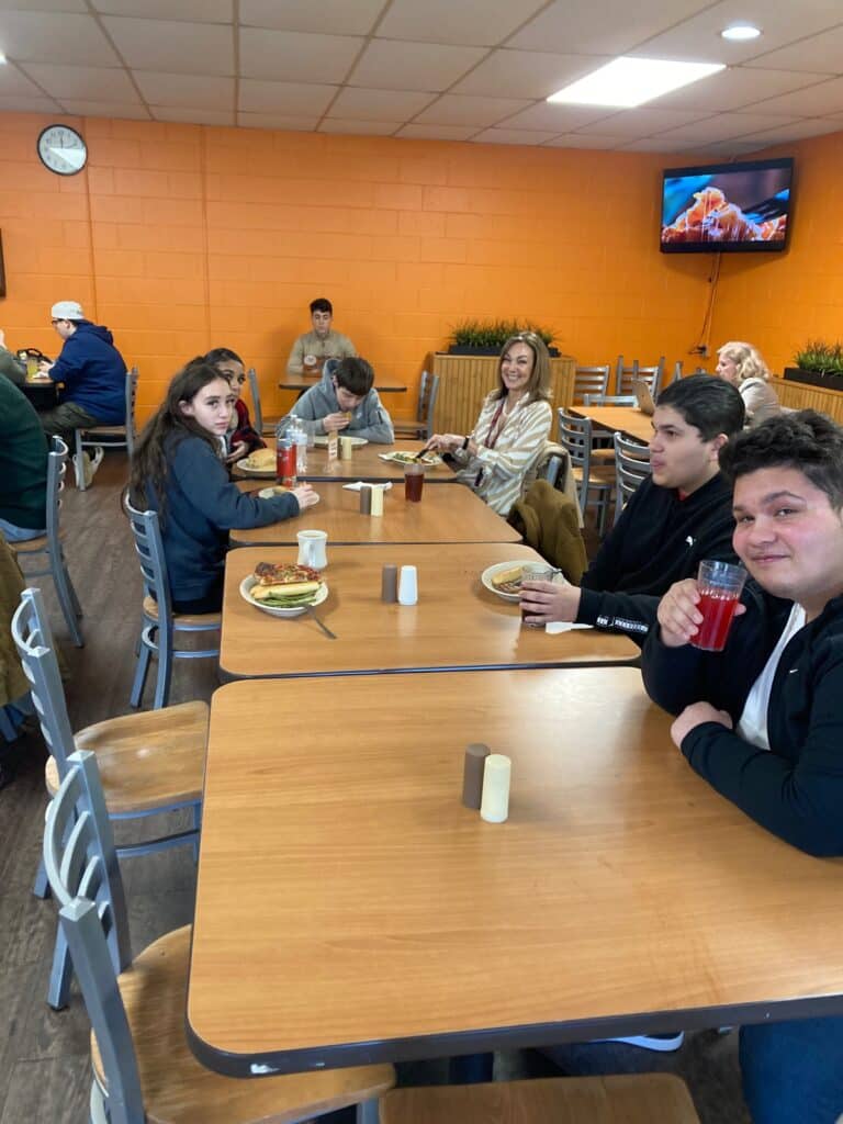 A group of people sitting at tables in a restaurant.