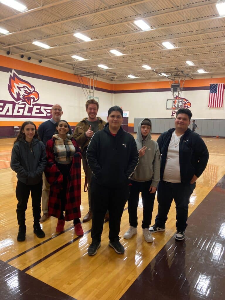 A group of people standing in front of an eagle logo.