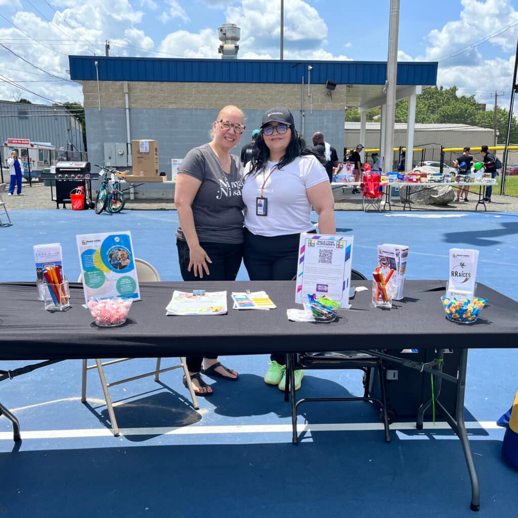 Two people standing next to a table with pamphlets.