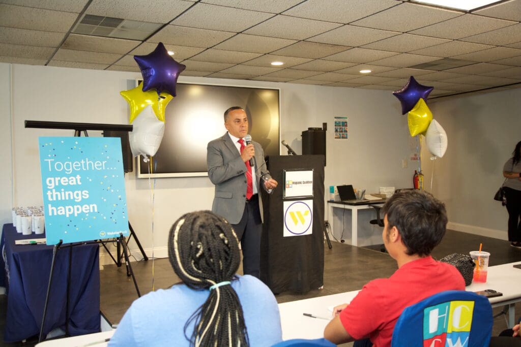 A man standing at a podium in front of people.