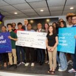 A group of people holding giant checks and signs.