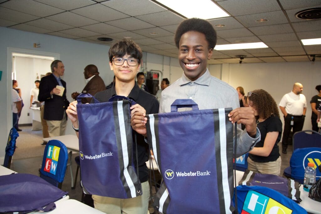 Two people holding up bags of water