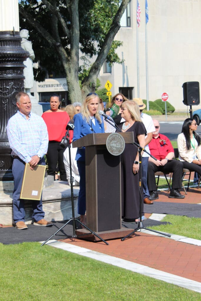 A woman standing at the podium with people behind her.